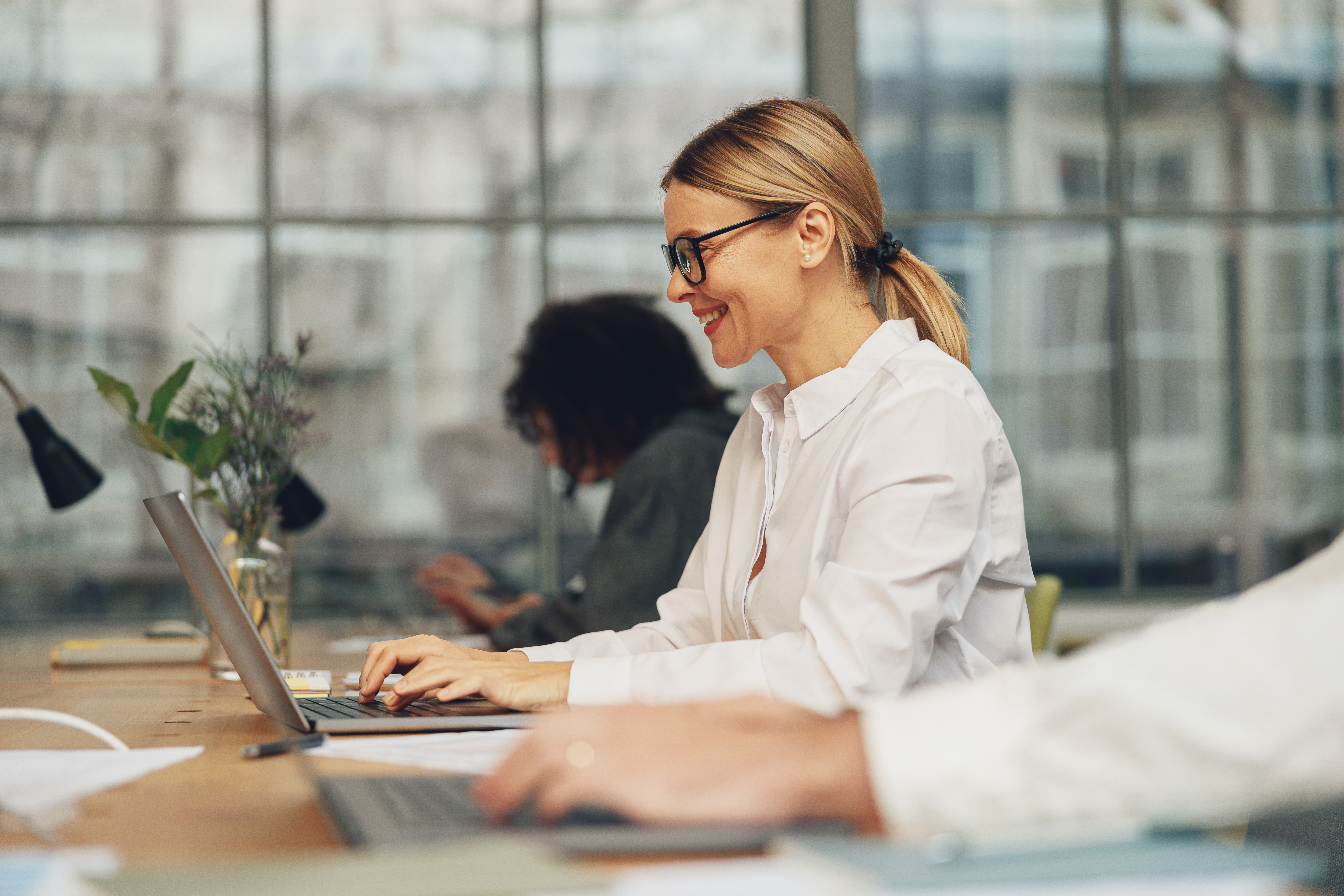 smiling-woman-manager-working-on-laptop-in-modern-2023-07-12-00-56-07-utc